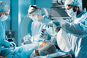 african american anesthetist holding oxygen mask