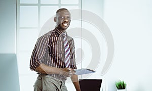 African american architect working with computer and blueprints in office