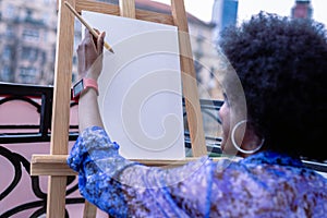 African-American artist wearing red smart watch working outside