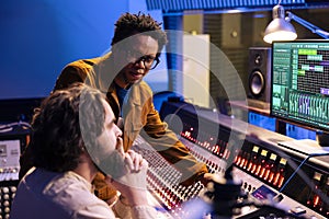 African american artist works with producer in professional studio