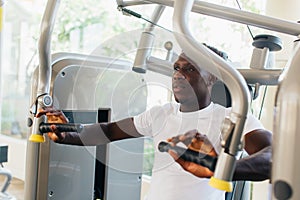 African American athlete doing exercise for chest muscles on pec deck machine during workout in gym