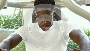 African American athlete doing exercise for chest muscles on pec deck machine during workout in gym