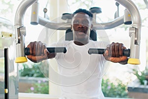 African American athlete doing exercise for chest muscles on pec deck machine during workout in gym
