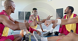 African American basketball players relax in a gym