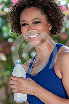 African American Biracial Woman Exercising Drinking Water Bottle