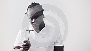 African american black man looking at medical reflex hammer. Isolated on white background