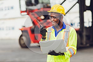 African American black worker working in logistic shipping cargo port site happy work control loading with radio and laptop