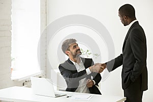 African-american boss congratulating caucasian employee with pro