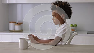 African american boy child play games on phone in kitchen Spbi. online addicted teenager sit and use