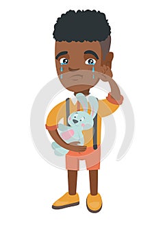 African-american boy crying and holding toy.