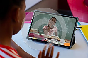 African american boy discussing mathematics homework with girl over video call on digital tablet