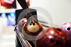 African American boy picking up a bowling ball hobby and leisure concept