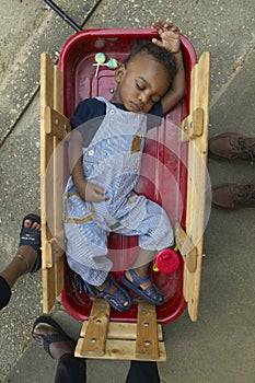 African-American boy sleeping in little Red Wagon in Central GA