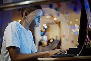 African american boy using a computer at night