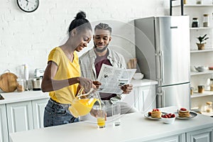 african american boyfriend reading newspaper and girlfriend