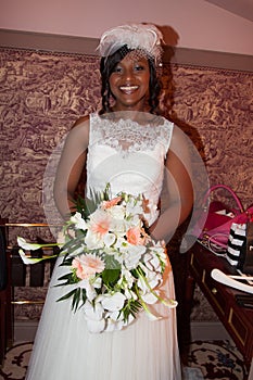 African american bride smiling at the camera holding bouquet