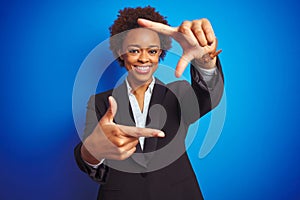 African american business executive woman over  blue background smiling making frame with hands and fingers with happy