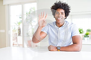 African American business man showing and pointing up with fingers number four while smiling confident and happy