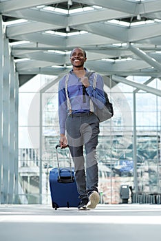 African american business man walking at airport with luggage