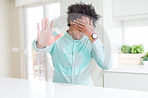 African American business man wearing elegant shirt covering eyes with hands and doing stop gesture with sad and fear expression