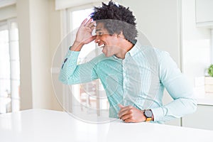 African American business man wearing elegant shirt very happy and smiling looking far away with hand over head