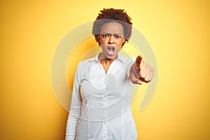 African american business woman over isolated yellow background pointing displeased and frustrated to the camera, angry and