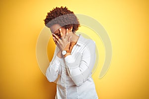 African american business woman over  yellow background with sad expression covering face with hands while crying