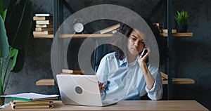 African american business woman professional talking on phone while sitting at office desk. Young female student make