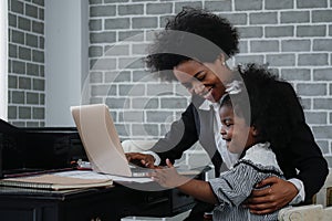 African american business woman taking care of her little daughter while working at home