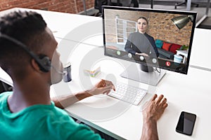 African american businessman discussing on video conference with caucasian businesswoman in office