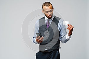 African-american Businessman holding Credit Card and mobile cellular phone
