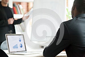 African american businessman listening to presentation, rear clo