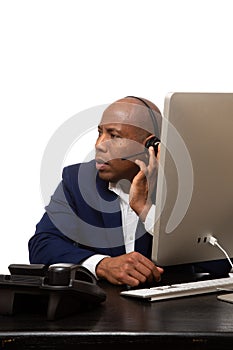 African American Businessman Listens Through Headset At Desk