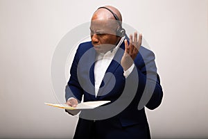 African American Businessman Listens Through Headset While Holding File