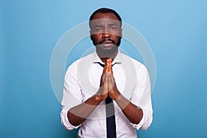 African american businessman praying with hands together with hope