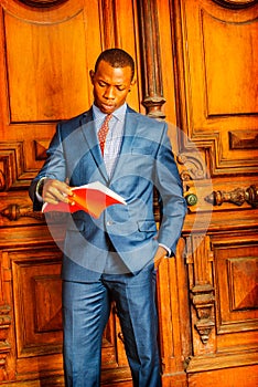 African American Businessman reading red book.
