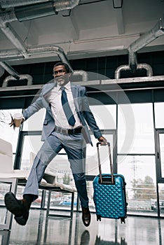 African american businessman running for flight at airport