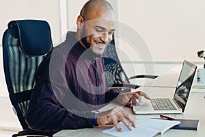 African american businessman sitting at a computer in his startup office