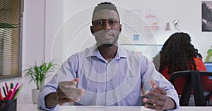 African american businessman sitting at desk, making video call in modern office