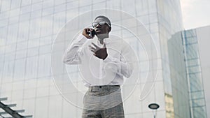 African American Businessman talking on cell phone, standing near his office