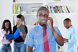 African american businessman with tie at phone with colleagues