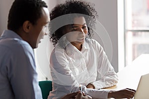 African American businesswoman mentor helping male trainee with project photo