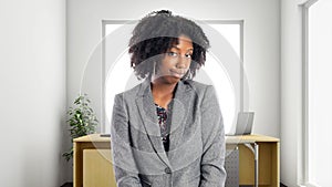 African American Businesswoman In an Office Looking Shy or Embarrassed