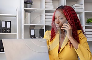 African American businesswoman talking on the phone while working in the office with stress
