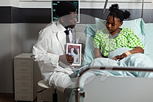 African american cardiologist doctor holding tablet explaining heart radiography