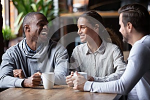 African American and Caucasian friends having fun together in coffeehouse