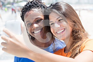 African american and caucasian girls taking photo