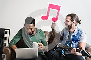 African American and Caucasian male in a songwriting process holding musical note