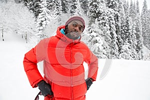 African American Cheerful black man in ski suit in snowy winter outdoors