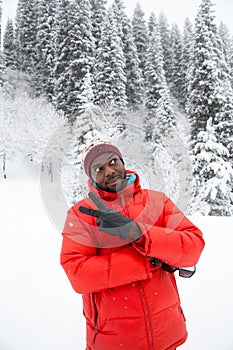 African American Cheerful black man in ski suit in snowy winter outdoors